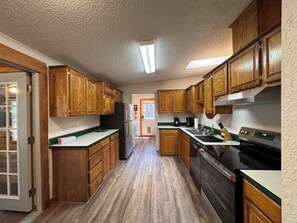 A kitchen with wooden cabinets, a refrigerator, a stove, and a dishwasher. - Come and enjoy a relaxing getaway in beautiful Ruidoso! Minutes from everything (Ruidoso)