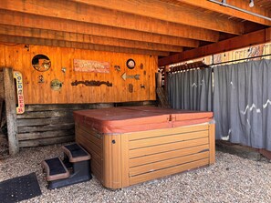 A wooden cabin with a hot tub, a wooden bench, and a sign that reads 'COLD BEER'. - Come and enjoy a relaxing getaway in beautiful Ruidoso! Minutes from everything (Ruidoso)