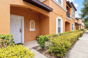 A row of townhouses with a uniform architectural style, featuring arched doorways and a consistent color scheme. - Magic 3B/3B Family Escape/Near Parks (Kissimmee)
