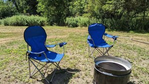 Two blue folding chairs and a metal barrel in an outdoor setting. - Secluded 6BR Retreat Near Lake Hopatcong (Roxbury Township)