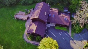 A single-story house with a sloped roof, a fenced yard, and a paved driveway. - Secluded 6BR Retreat Near Lake Hopatcong (Roxbury Township)