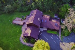 A single-story house with a sloped roof, a fenced yard, and a paved driveway. - Secluded 6BR Retreat Near Lake Hopatcong (Roxbury Township)