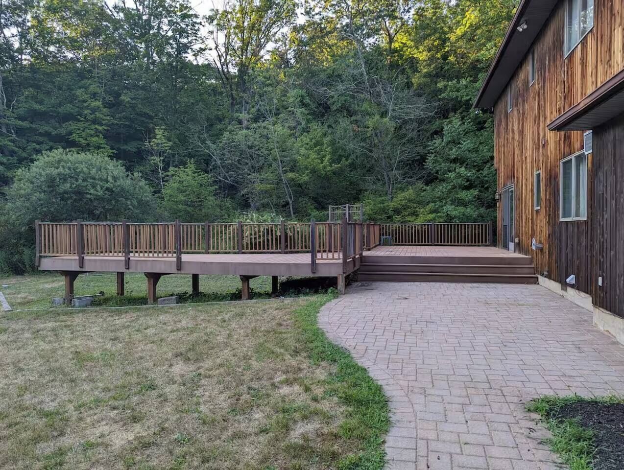 A wooden building with a brick pathway leading to a wooden deck.