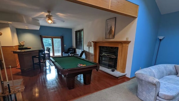 A living room with a pool table, a fireplace, and a blue wall. - Secluded 6BR Retreat Near Lake Hopatcong (Roxbury Township)