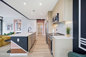 A modern kitchen with a central island, built-in appliances, and a view to the living area.