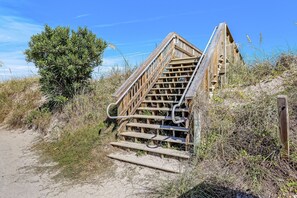 A wooden staircase leading up to a building with a metal handrail. - 3BR/3BA Multilevel Condo | Steps to Pool & Beach | Monthly Stays (Fernandina Beach)