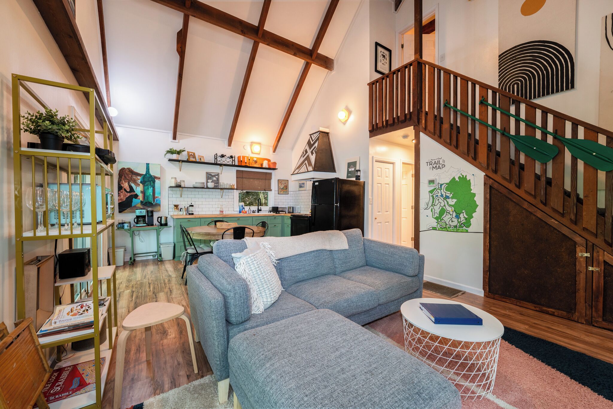 A spacious living area with a sofa, a dining table, and a kitchen in the background.