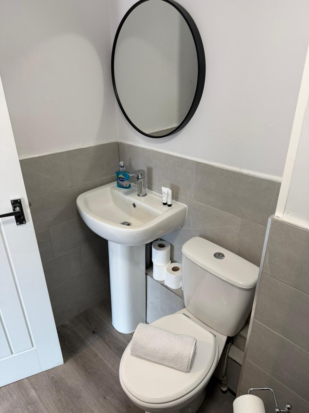 Un bagno con un lavandino bianco, un water e uno specchio.