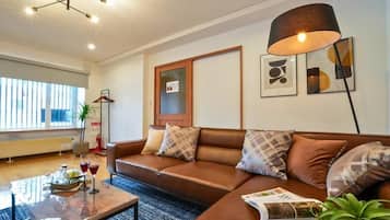 A modern living room with a brown leather sofa, a coffee table, and a floor lamp.