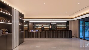 Eine moderne Bar mit poliertem Boden, einem Empfangsbereich und Regalen voller Flaschen.