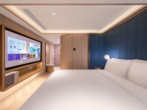 A modern hotel room with a large flat-screen TV mounted on the wall, a bed with white linens, and a blue accent wall. - Crystal Hotel Beijing TianTan (Beijing)