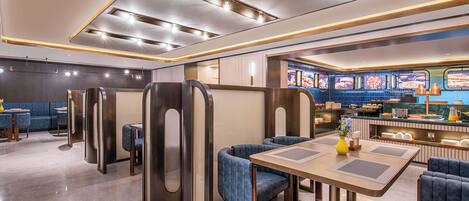 A modern restaurant interior with booths, a bar area, and a counter with a menu display.