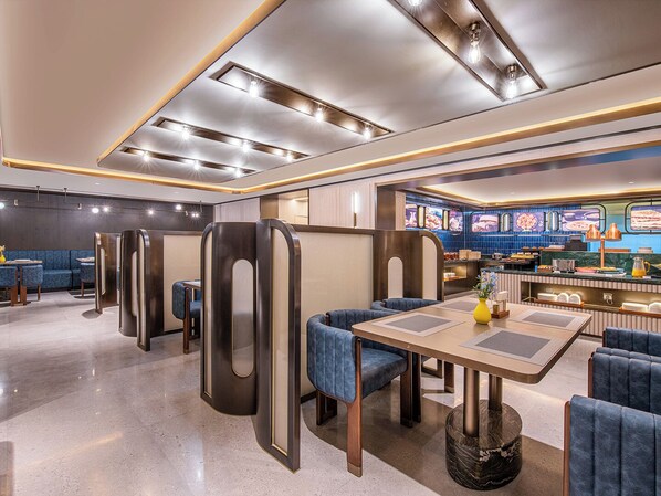 A modern restaurant interior with booths, a bar area, and a counter with a menu display.
