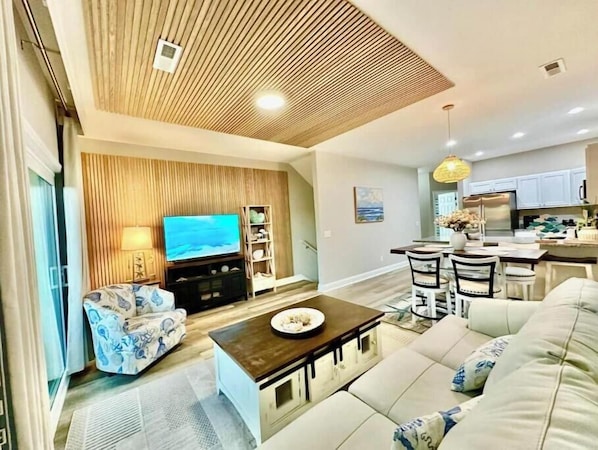 Una sala de estar moderna con un sofá, una mesa de centro y una televisión.