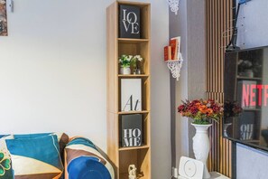 A living room with a bookshelf, a TV, and a decorative vase.