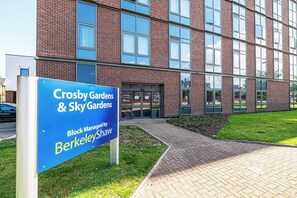 Un immeuble avec une enseigne bleue indiquant « Crosby Gardens & Sky Gardens », géré par Berkley Shaw.