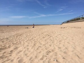 Une plage de sable fin sous un ciel dégagé.