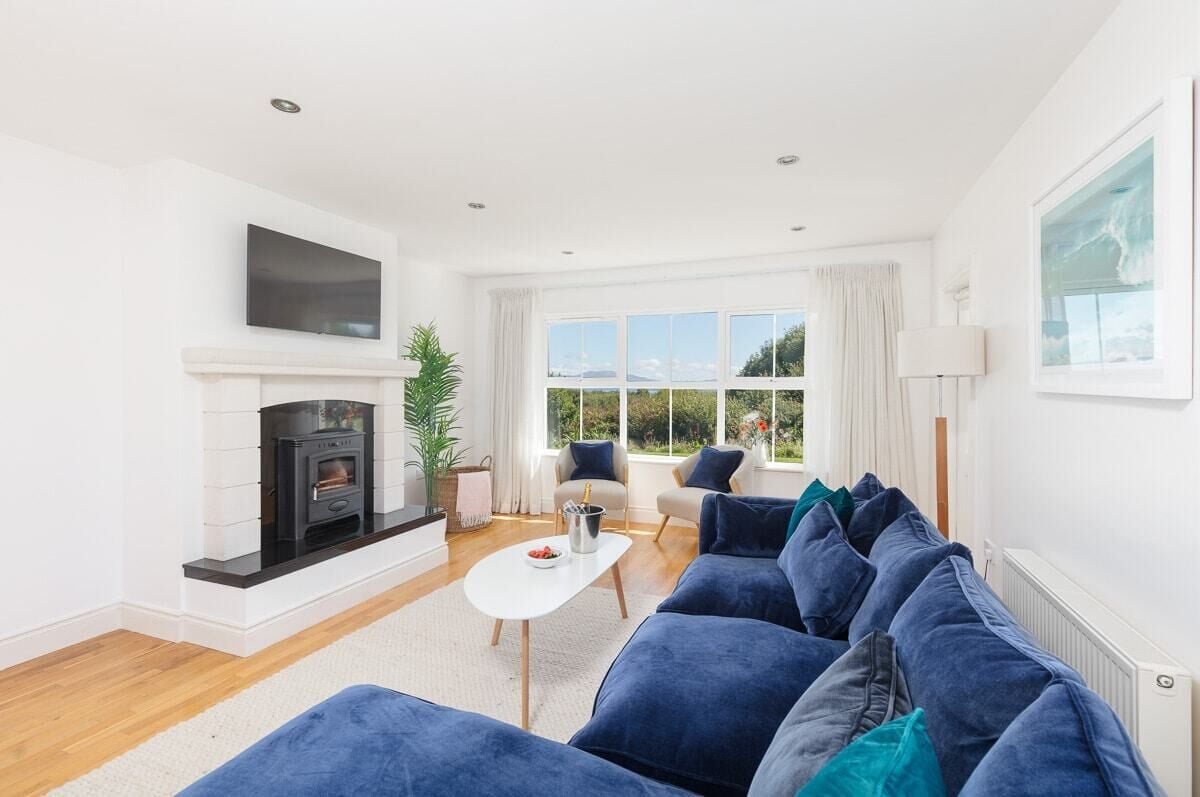 A modern living room with a fireplace, a sofa set, and a television.