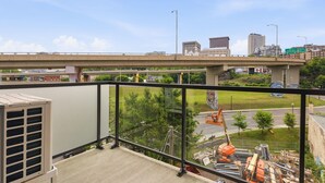 Uma varanda com vista para a paisagem urbana, incluindo uma ponte e edifícios.