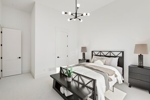 A modern bedroom with a bed, bedside tables, a desk, and a hanging light fixture. - Modern House in Chaska (Chaska)