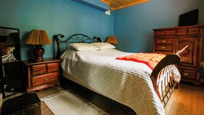 A bedroom with a bed, two bedside tables, a dresser, a mirror, and a television. - Chop Wood, Carry Water - Lake front cottage with a cozy vibe (Sandy Hook)