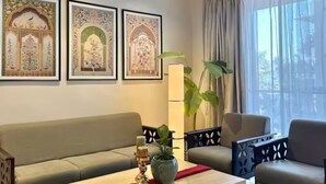 A living room with a sofa, armchairs, a coffee table, and decorative wall art.
