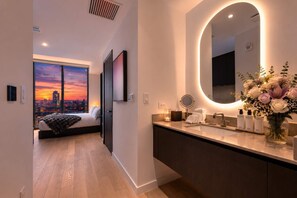 A modern hotel room with a large bed, a city view, a bathroom with a vanity, and a mirror. - Elite E11EVEN Studio with Rooftop Pool & Resort Gym (Miami)