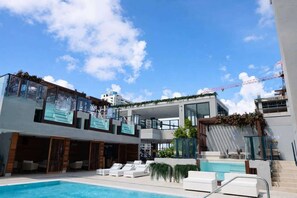 A modern hotel with a pool, outdoor seating, and a view of the city skyline. - Elite E11EVEN Studio with Rooftop Pool & Resort Gym (Miami)
