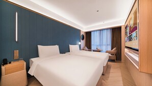 Ett hotellrum med en stor säng, sängbord, ett skrivbord och en stol.