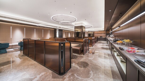 En modern hotellobby med en sittgrupp, en buffé och en receptionsdisk.