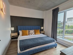 A modern hotel room with a large bed, a city view, and a contemporary design. - The Zenith · Sleeps 8 · 11th fl · EV parking (Québec City)