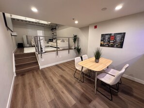 Ein modernes Interieur mit Essbereich, Treppe und Wohnbereich.