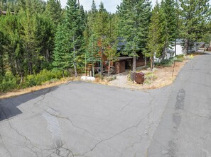 A residential area with a wooden cabin, a paved driveway, and a mailbox.
