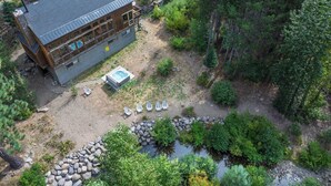 Eine Lodge mit großer Terrasse, Whirlpool und Teich.