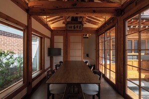 A traditional Japanese-style room with a long wooden table, chairs, and sliding doors. - The Prima Hotel Hanok Dambakjae Gyedong (Seoul)
