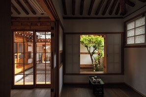 A traditional Japanese room with sliding doors, a window with a view of a tree, and a small table with tea set. - The Prima Hotel Hanok Dambakjae Gyedong (Seoul)