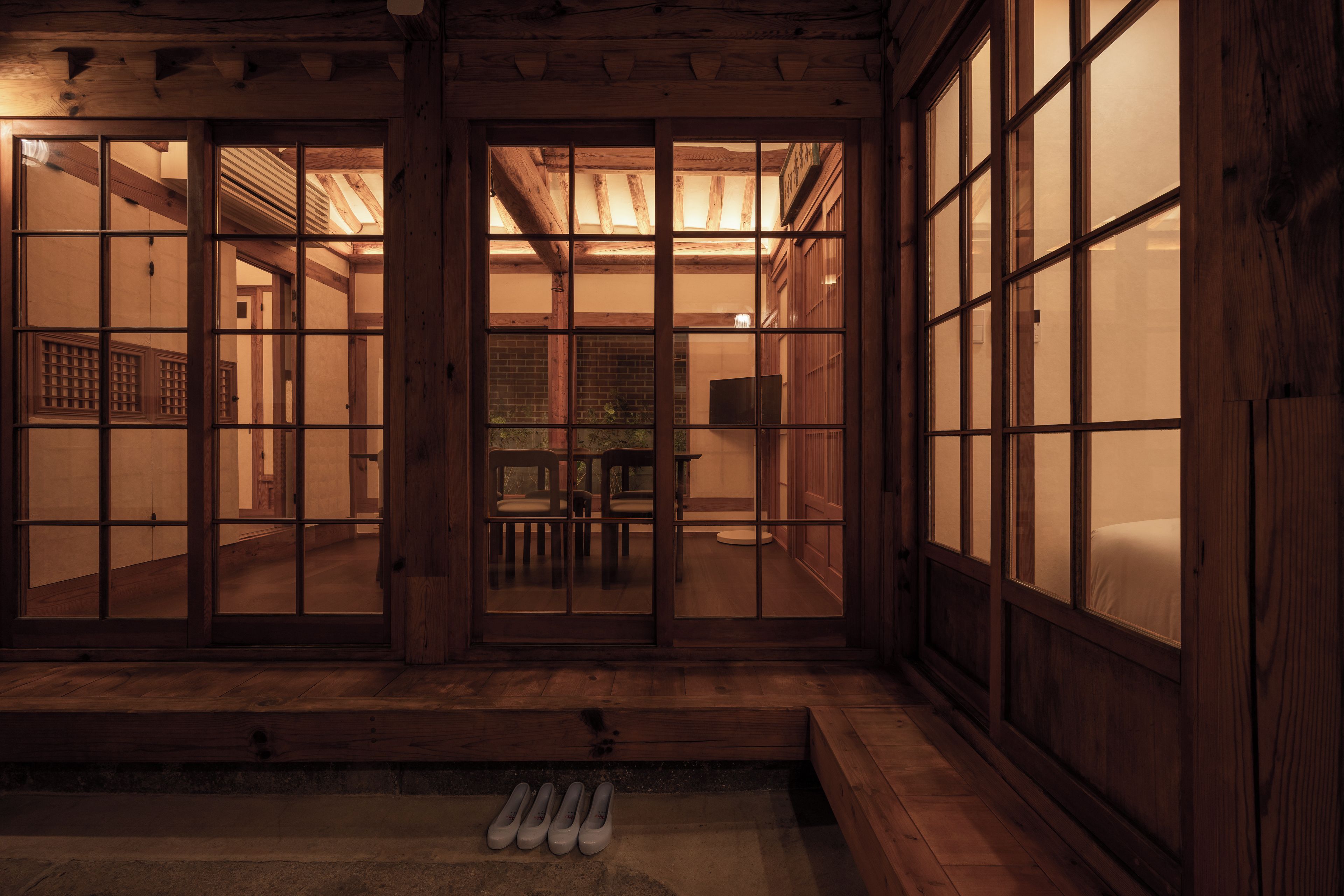 A traditional Japanese-style room with sliding doors, a tatami mat floor, and a low wooden bench.
