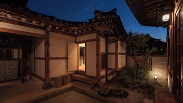 Un bâtiment traditionnel en bois, doté d’une entrée carrelée et d’un petit jardin.
