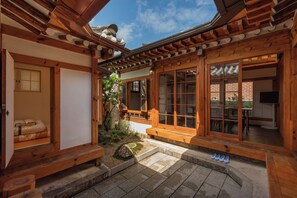 A traditional Japanese-style building with wooden architecture, a stone courtyard, and a view of the sky. - The Prima Hotel Hanok Dambakjae Gyedong (Seoul)