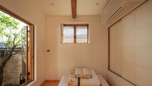 Una habitación con cama, ventana y vistas al exterior con vegetación.