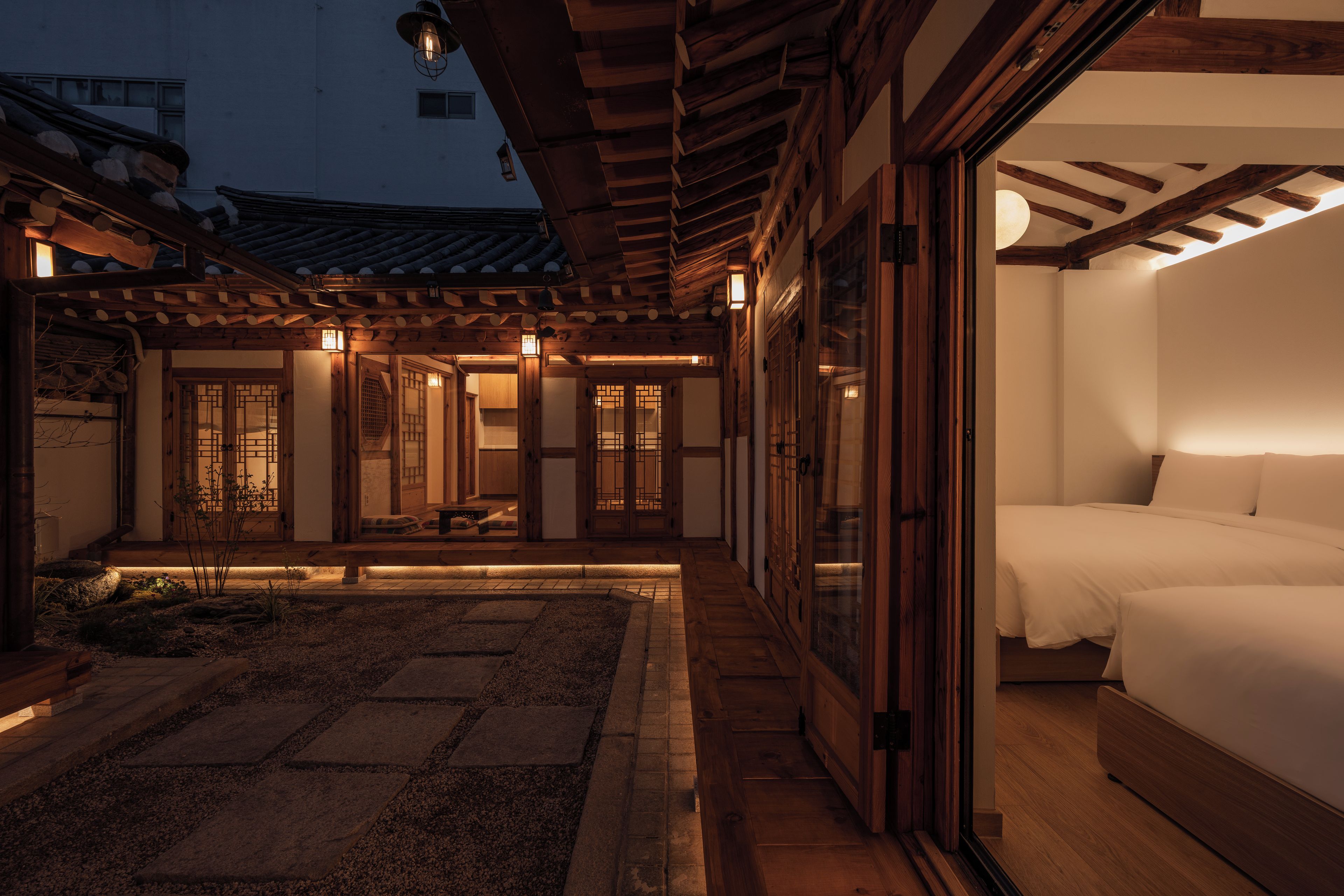 A traditional Japanese-style room with tatami flooring, a low wooden ceiling, and sliding doors.