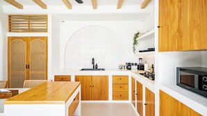 Una cocina moderna con armarios de madera, una isla central y un microondas integrado.