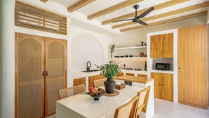 Una cocina moderna con armarios de madera, una isla central y un ventilador de techo.