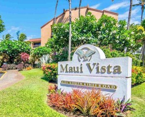A sign for 'Maui Vista' with a building in the background. - “Kīhei Hideaway” @Maui Vista, 30 Sec the Beach, Ground Floor, King Bed & AC (Kihei)