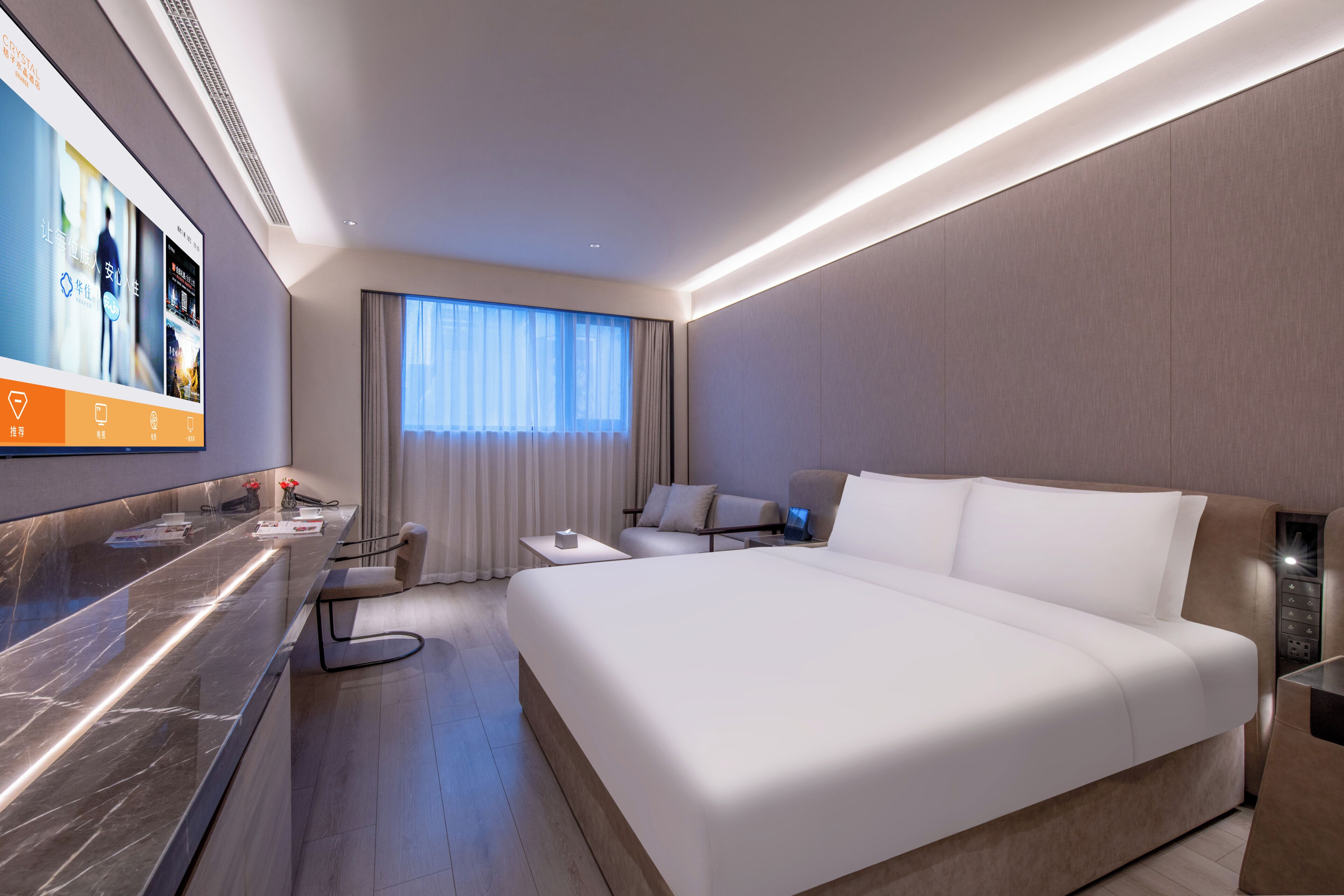 A modern hotel room with a large bed, a desk, and a television displaying hotel services.