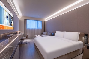 A modern hotel room with a large bed, a desk, and a television displaying hotel services. - Crystal Hotel Beijing Guomao Heshenghui (Beijing)