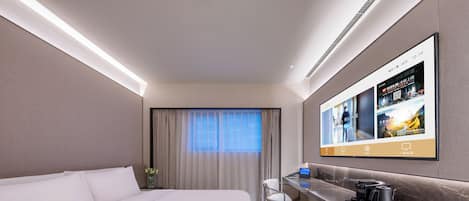 A hotel room with a bed, a desk, a flat-screen TV, and a window with curtains.