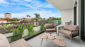 A balcony with a sofa, two chairs, and a small coffee table. - Beautiful Melbourne Beach Retreat | Pool, Hot Tub & Private Balcony 🌴 (Melbourne Beach)