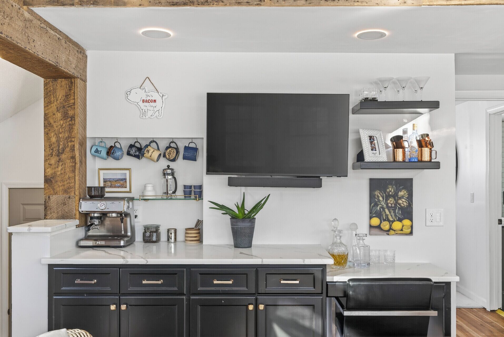 A modern kitchen with a flat-screen TV, a coffee machine, and various kitchenware.