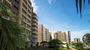 A multi-story residential building with balconies, surrounded by greenery and a clear sky. - Costa Azul Apt: Pool Access Near La Vela Mall (Costa Azul)